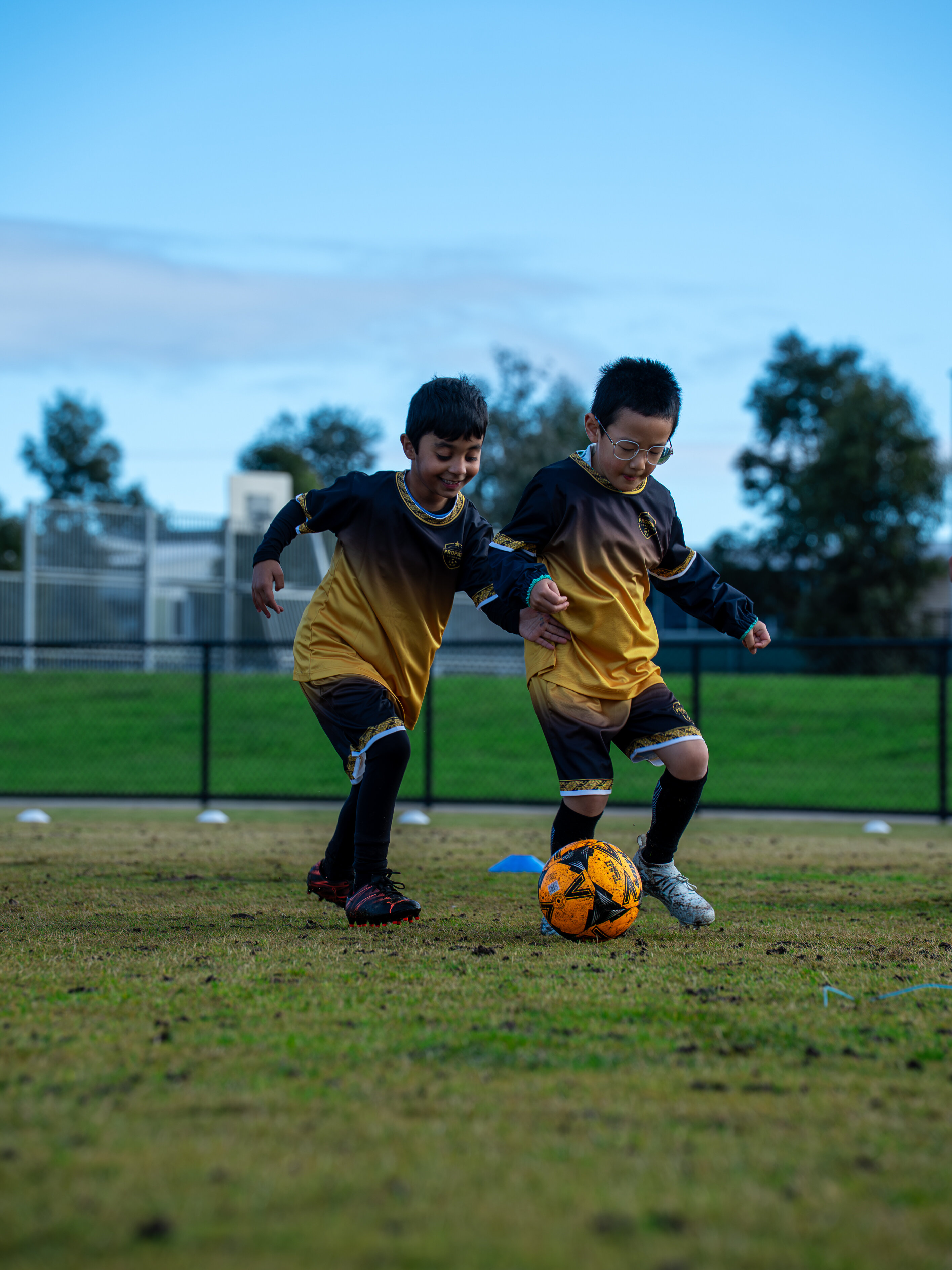 Two young ProPath Academy players competing for the ball