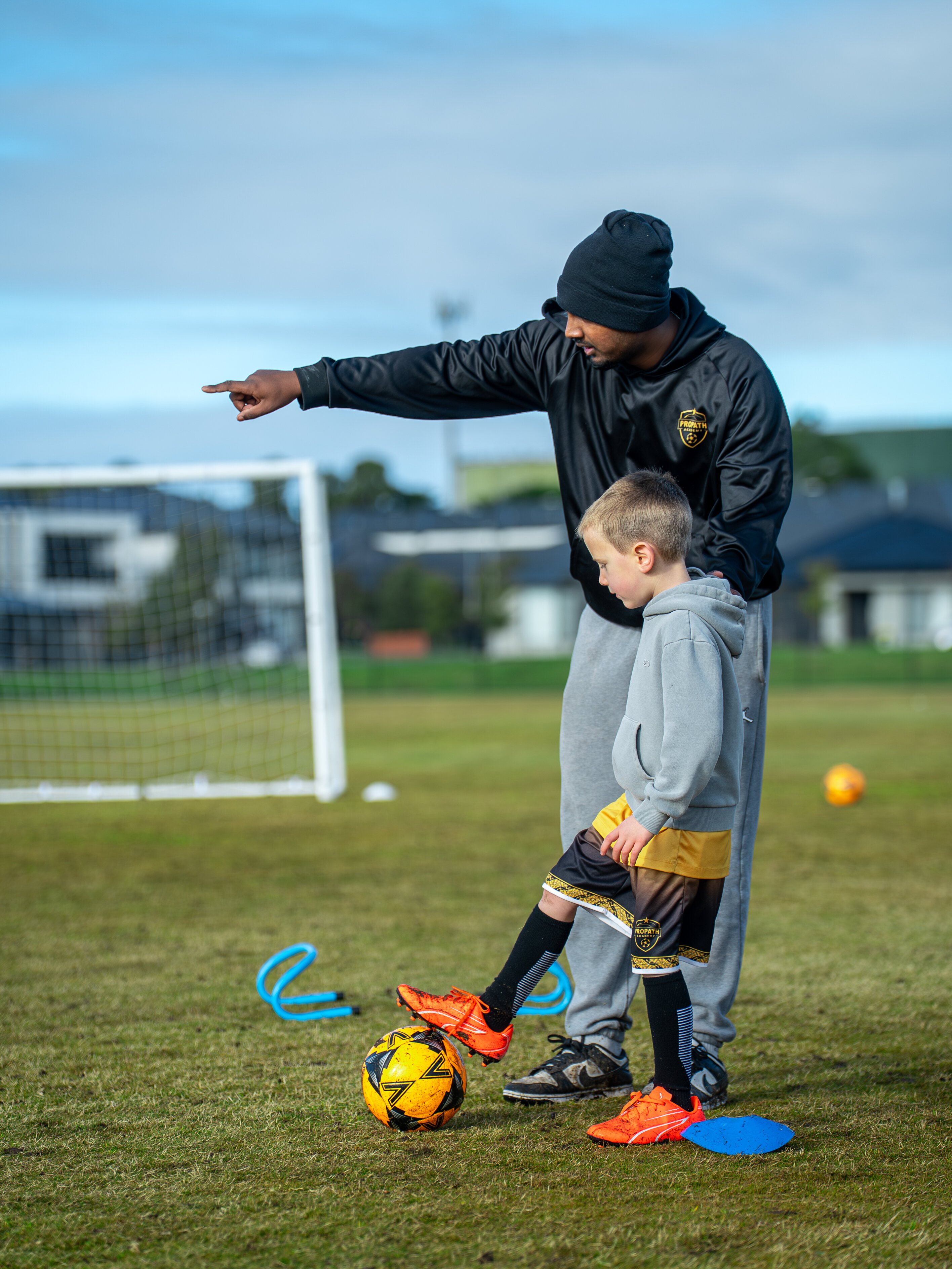 Coach giving one-on-one direction to a young footballer