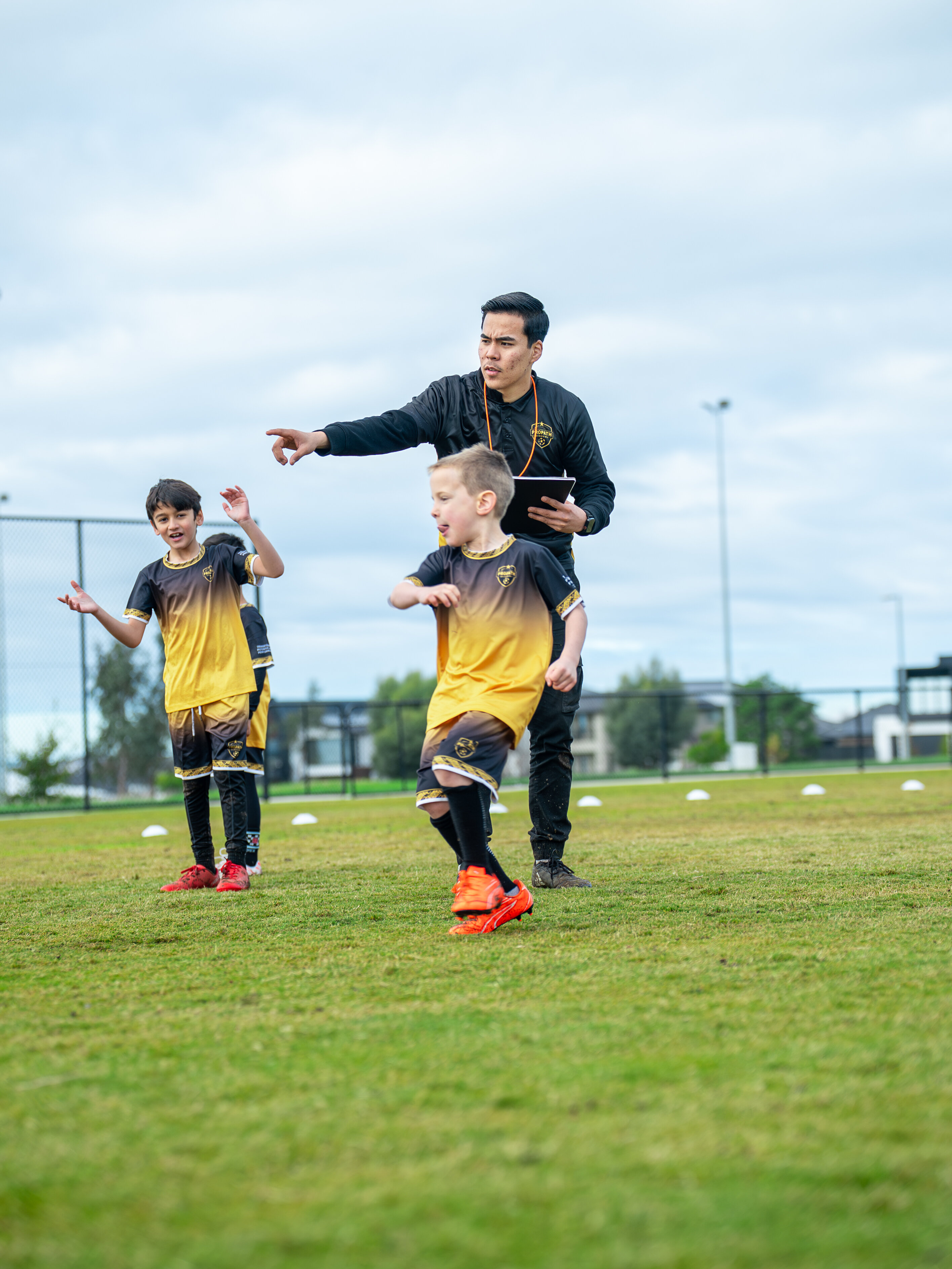 Coach guiding players through movement during football training
