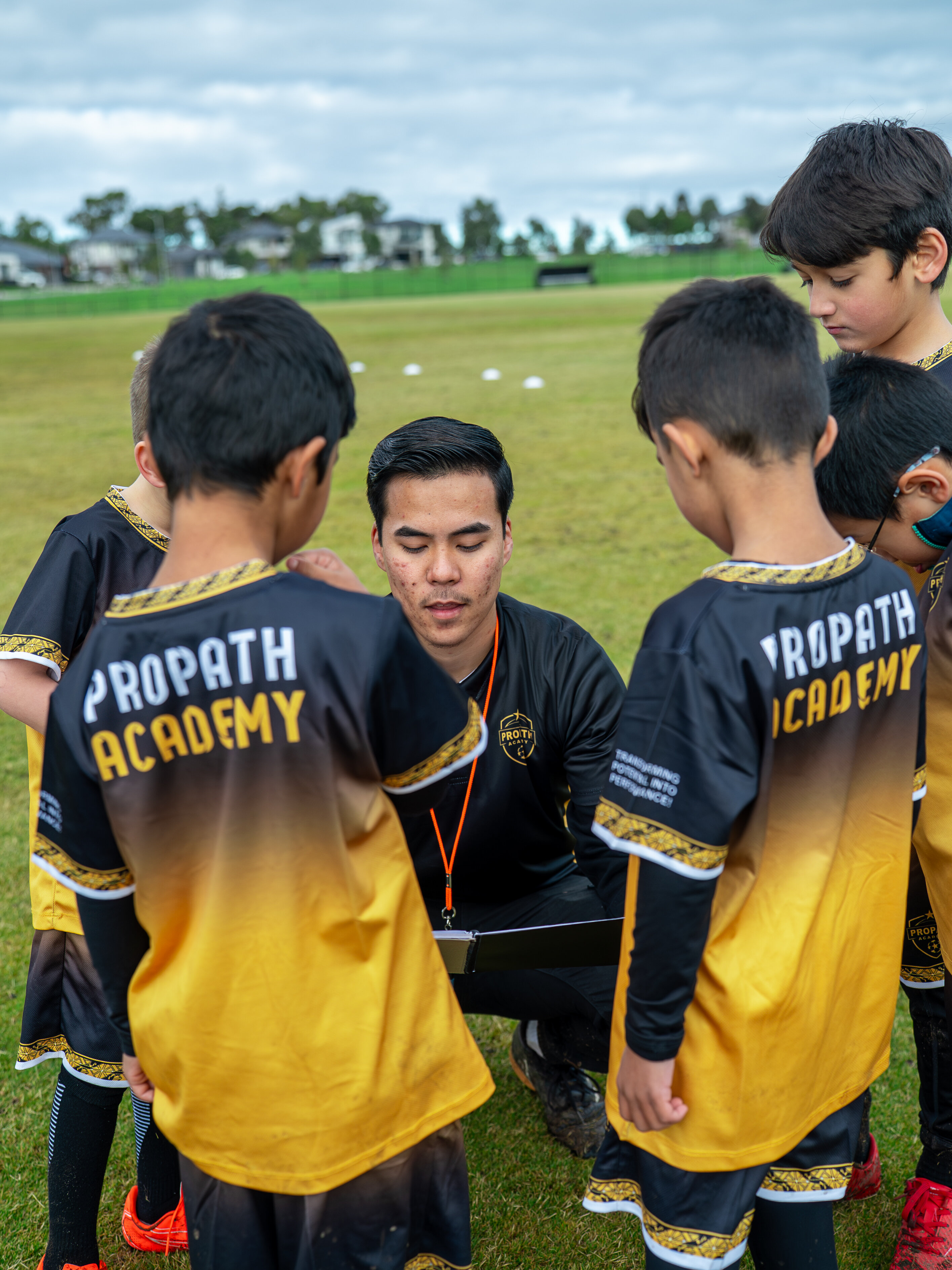 ProPath Academy players gathered around a coach for instruction